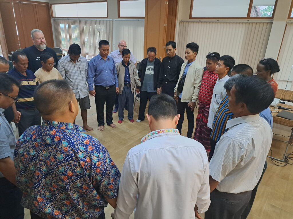 Diverse group of people praying together in unity